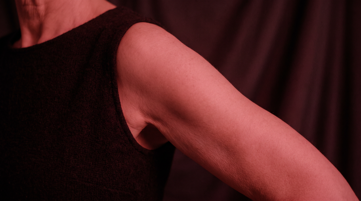 Shoulder of a woman bathed in soft deep red light