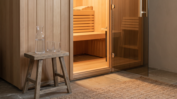 Water carafe and glasses beside an open sauna door