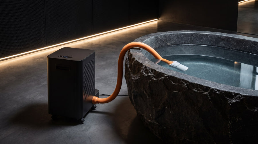 Norge N-03 in Black beside a carved stone plunge in a dark spa lit from a warm cove